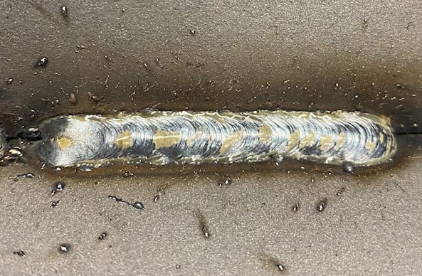 Closeup showing excessive spatter on base metal around joint